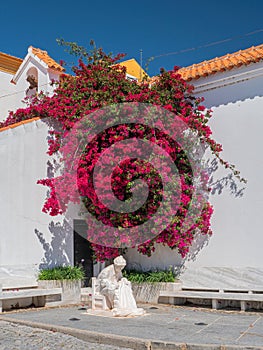 Fisherman statue and Bougainvillea bush, Alcoutim, Portugal.