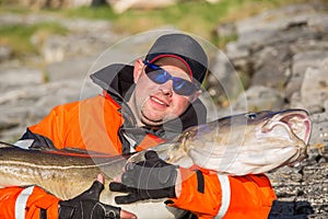 Fisherman in sunglasses holds a big fish