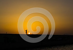 Fisherman at sunset in Alimos marina in Athens, Greece