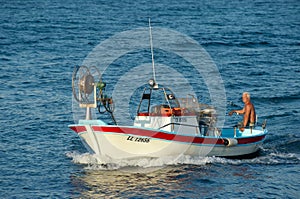 Fisherman swims on his fishing boat