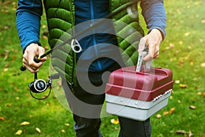 Fisherman with tackle box and fishing rod