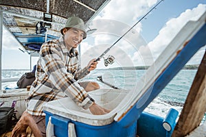 Fisherman taking bait in a box in small fishing boat