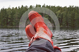 Fisherman taking a break with rubber boots resting on bulwark. photo