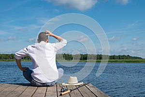 Fisherman thinks how to catch fish on a river in sunny weather