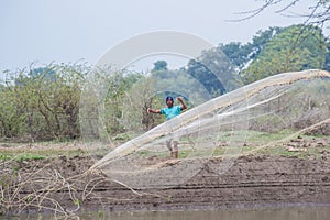 Fisherman Throwing Net in the Pond