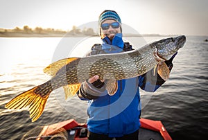 Fisherman and trophy Pike. Fishing background.