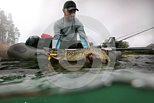 Fisherman and trophy Pike. Fishing background.