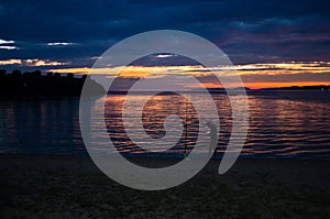 Fisherman at twilight in Toroni bay near old roman fortress, Sithonia