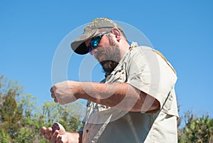 Fisherman tying a hook onto fishing line