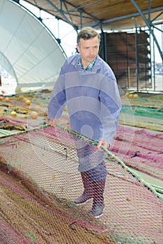 Fisherman untangling his nets