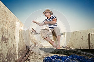 Fisherman untangling the net