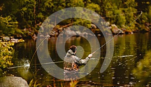 Fisherman using rod fly fishing in mountain river