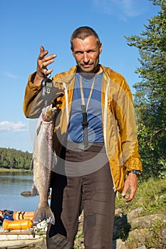 Fisherman weighs a beautiful salmon.
