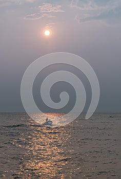 The fisherman and wooden fishing boat used as a vehicle for finding fish in the sea