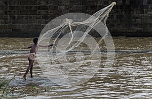 The fisherman in work with a fishing net, eager to earn livelihood