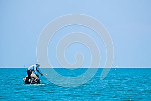 Fisherman Working in the Sea with Shell to Trap a Small Squid