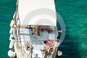 The fisherman working on white fishing boat and fish in the Mediterranean sea port