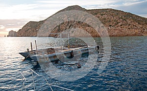 Fishermans early dawn sunrise view of bait supply boat at Lands End in Cabo San Lucas in Baja California Mexico