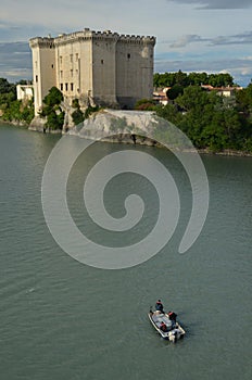 Fishermen in boat on river Rhone under castle Tarascon