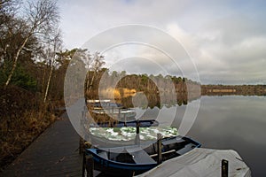 Fishermen boats in a lake during autumn time. Clouds reflecting on water