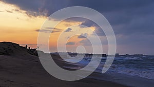 Fishermen catch fish on the seashore at sunset