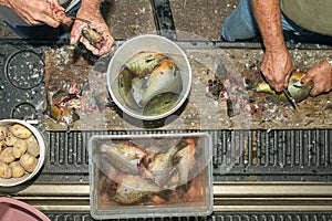 Fishermen cleaning a catch of redbreast sunfish