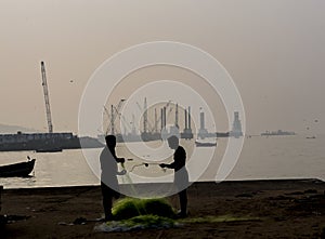 Fishermen cleaning nets on a port background photo