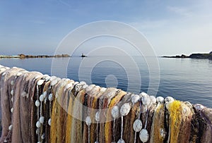 Fishermen colorful nets in front of calm sea water and clear sky. Seaside landscape, wallpaper