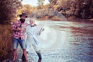 Fishermen with fishing rod on the river. Fly fishing. Men fishing in river during summer day. Family and generation -
