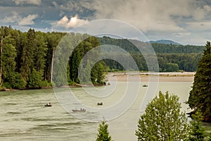 Fishermen fishing for salmon on the Skeena River below Terrace, during a cloudy day in summer, in British Columbia, Canada