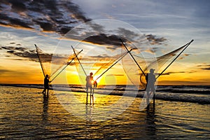 Fishermen fishing in the sea at sunrise