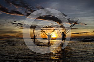 Fishermen fishing in the sea at sunrise