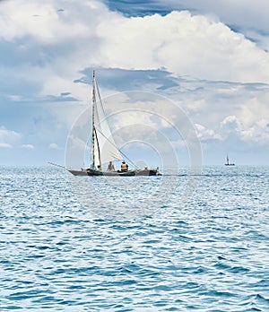 Fishermen fishing on a white sailboat