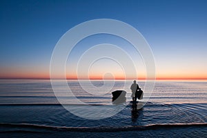 Fishermen going to his boat in sea on surise