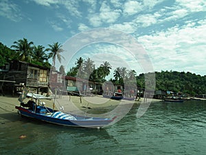 Fishermen houses and fishing boats and pirogues in Pulau Pangkor, Malaysia photo