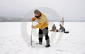 Fishermen ice fishing on a frozen lake in Norway