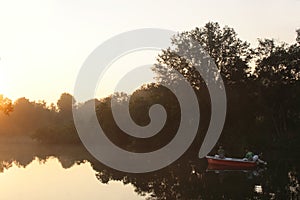 Fishermen on lake during sunrise