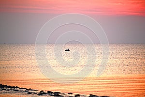 Fishermen leave fishing in the middle of the sea while sunrise n