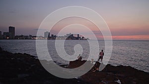 Fishermen at the Malecon at dusk in Havana, Cuba