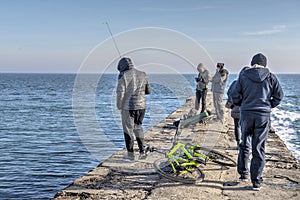 Fishermen on the pier by the sea