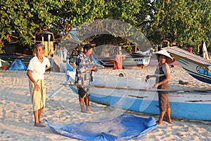 Fishermen preparing fish nets at sunset.