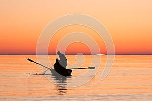 Fishermen pulling fishing net in sea on sunrise