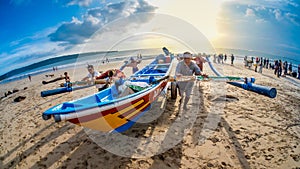 Fishermen pushing fishing boat together at Jimbaran Bali