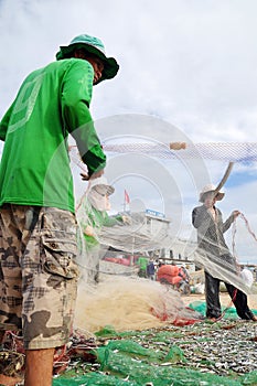 Fishermen are removing anchovies fish from their nets to start a new working day in Ly Son island