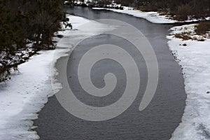 Fishermen on the river in winter ice fishing before