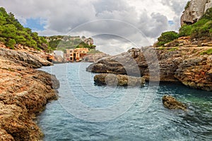 Fishermen`s houses in Cala s`Almonia, on the coast of Migjorn, S