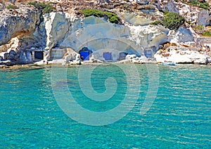 Fishermen`s huts carved into the rocky coast of Kimolos Island photo