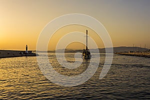 Fishermen and sailboat at sunset in Alimos marina in Athens, Greece