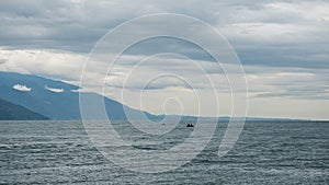 Fishermen in the sea on a small boat on a cloudy day