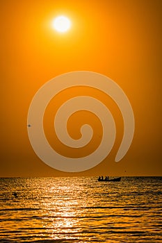 Fishermen silhouettes on the sea on a boat fishing in the mornin